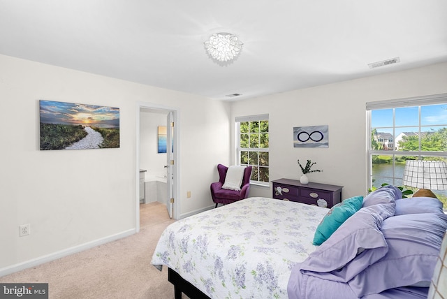 bedroom featuring baseboards, multiple windows, light colored carpet, and connected bathroom