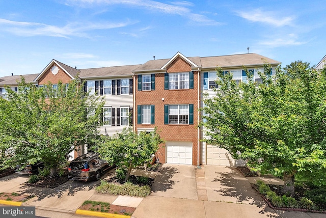multi unit property featuring concrete driveway, brick siding, and a garage
