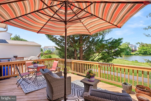 wooden terrace featuring a water view and outdoor dining area