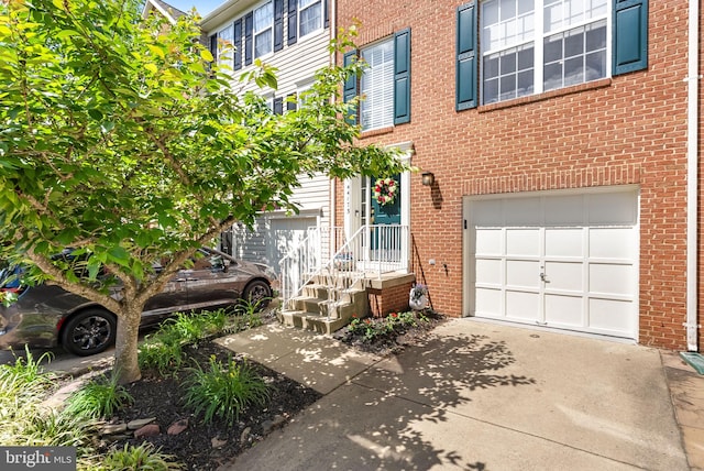 view of front facade with an attached garage, concrete driveway, and brick siding
