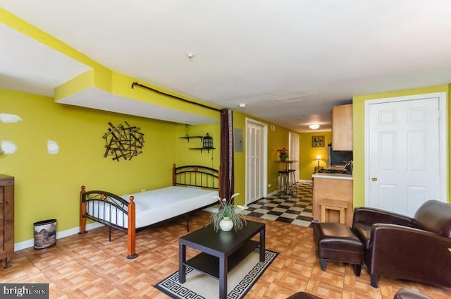 bedroom featuring baseboards and light floors