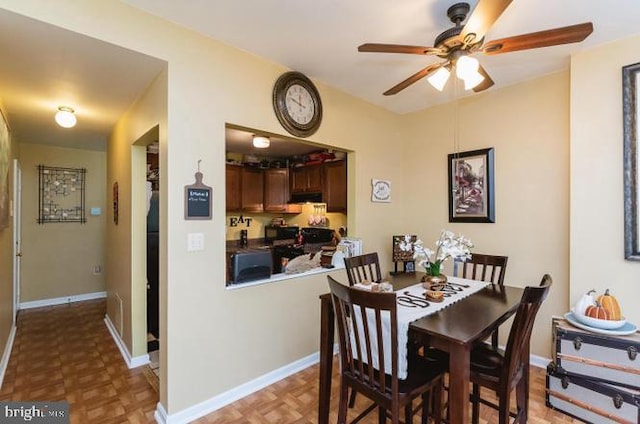 dining area with a ceiling fan and baseboards