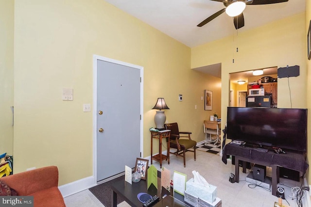 living room featuring a ceiling fan and baseboards