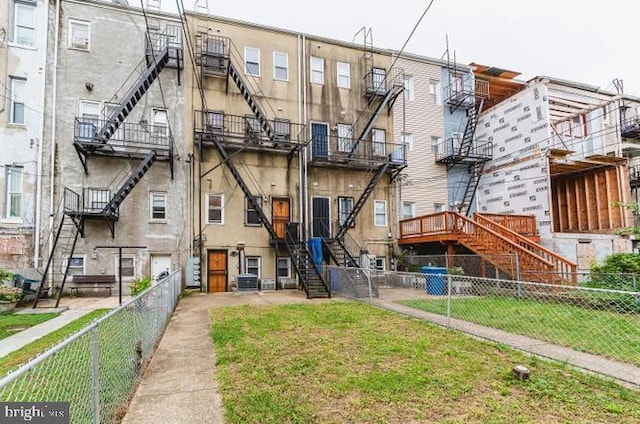 rear view of house featuring stairway and a fenced backyard