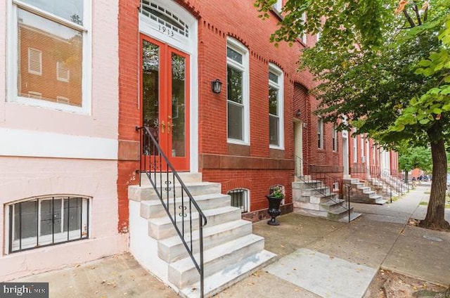 entrance to property featuring brick siding and french doors