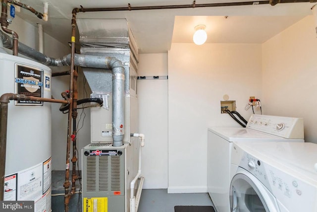 clothes washing area with gas water heater, washer and dryer, and baseboards