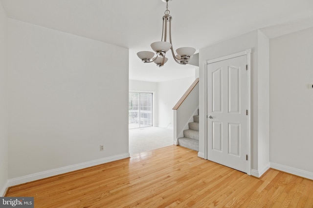 12473 Turtle Dove Pl, Waldorf, MD 20602 - unfurnished room featuring a chandelier, wood finished floors, stairway, and baseboards