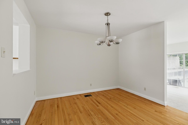 12473 Turtle Dove Pl, Waldorf, MD 20602 - unfurnished room featuring a chandelier, light wood-type flooring, and baseboards