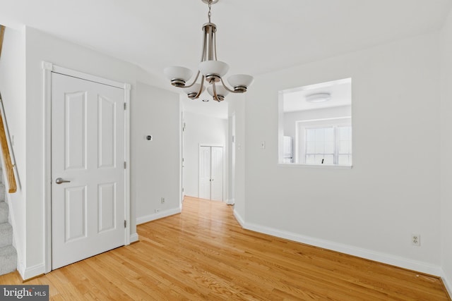 12473 Turtle Dove Pl, Waldorf, MD 20602 - unfurnished dining area with a chandelier, light wood-style flooring, and baseboards