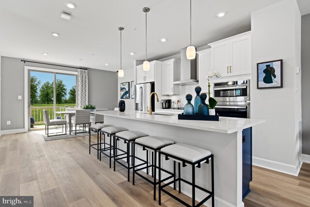 6830 Mathews Rd, Bryans Road, MD 20616 - kitchen featuring a sink, a kitchen breakfast bar, wall chimney range hood, white cabinets, and appliances with stainless steel finishes