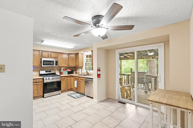 2 Bunting Bridge Rd, Cookstown, NJ 08511 - kitchen with stainless steel appliances, a sink, light countertops, a textured ceiling, and ceiling fan