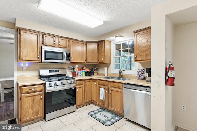 2 Bunting Bridge Rd, Cookstown, NJ 08511 - kitchen featuring stainless steel appliances, a sink, light countertops, a textured ceiling, and light tile patterned flooring