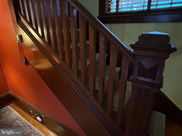 staircase with baseboards and wood finished floors