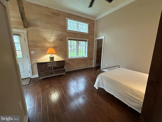 bedroom with wood walls, dark wood-style flooring, a baseboard radiator, and vaulted ceiling with beams