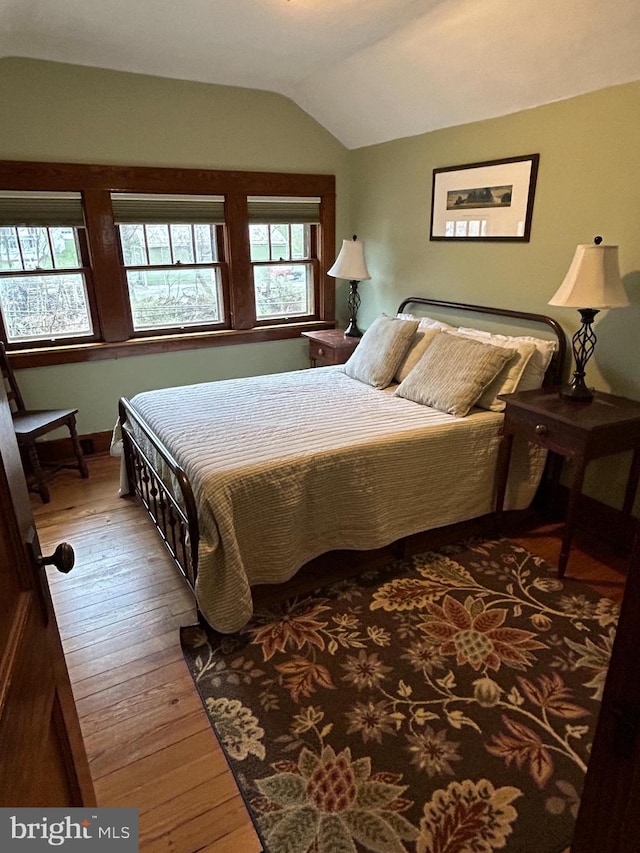 bedroom featuring hardwood / wood-style floors and vaulted ceiling