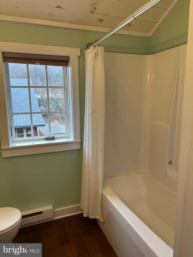 bathroom with toilet, shower / bath combo with shower curtain, wood finished floors, a baseboard heating unit, and baseboards