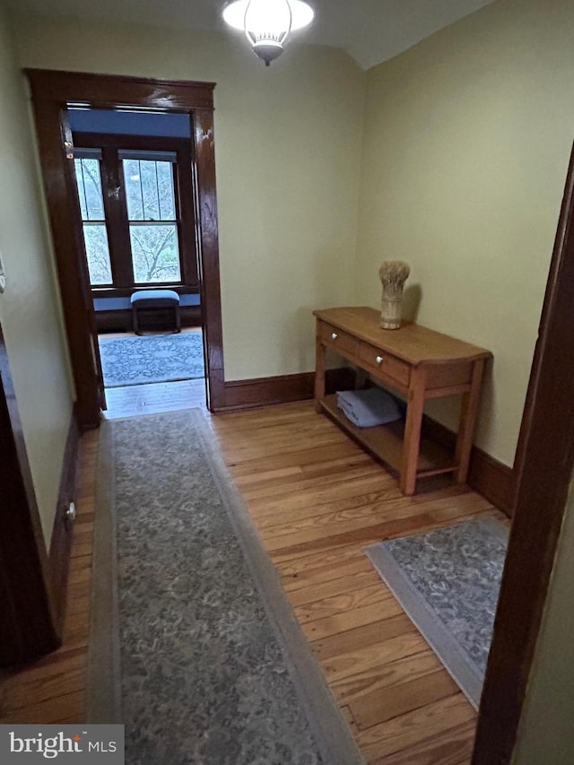 hall with baseboards and light wood-style flooring