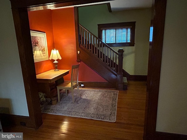 stairway featuring wood finished floors and baseboards