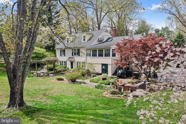 view of front facade with stairs, a patio area, a front lawn, a chimney, and an outdoor hangout area