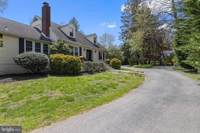 view of property exterior with a yard and a chimney