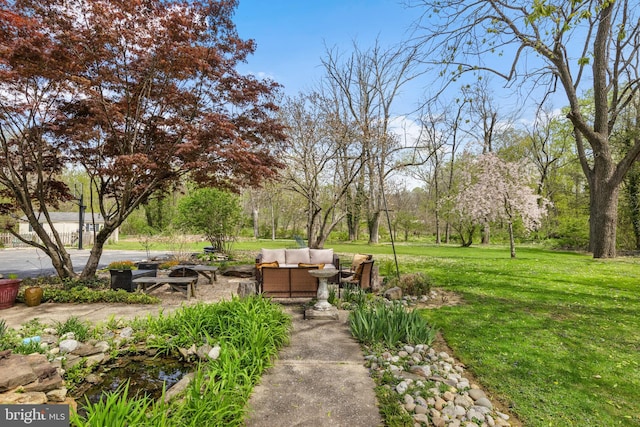 view of home's community with a lawn and an outdoor living space