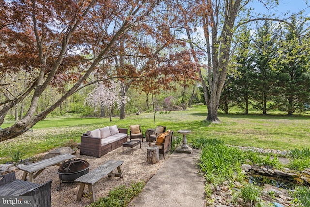 view of yard with an outdoor living space with a fire pit