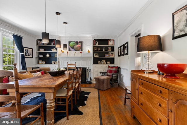dining room featuring crown molding, hardwood / wood-style floors, and built in shelves