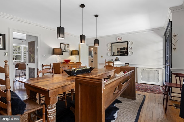 dining area with ornamental molding and hardwood / wood-style floors