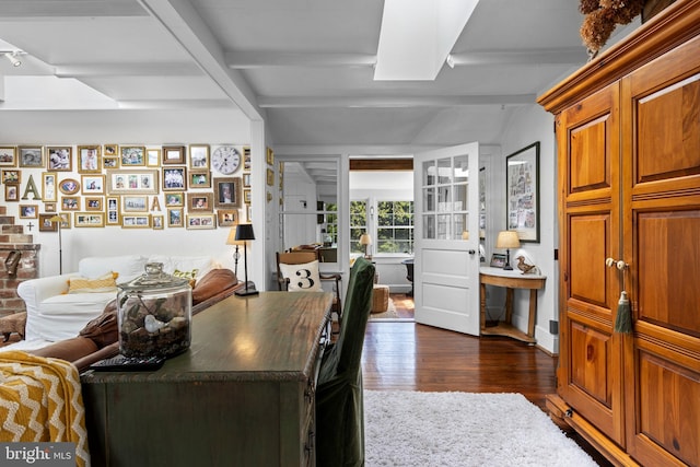 dining area with beamed ceiling and dark wood finished floors