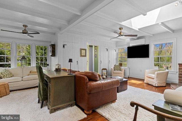 living room featuring a ceiling fan, an AC wall unit, and wood finished floors