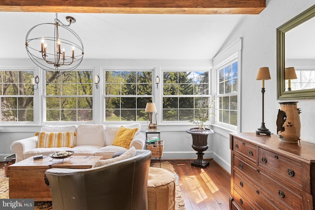 sunroom / solarium with baseboards, lofted ceiling with beams, wood-type flooring, and a notable chandelier