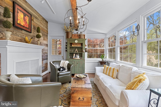 interior space featuring vaulted ceiling, plenty of natural light, a chandelier, and wood finished floors