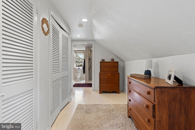 hall with light wood-style floors, recessed lighting, and vaulted ceiling