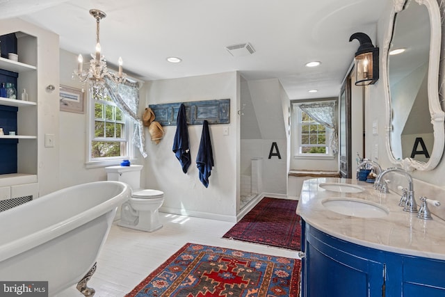bathroom with walk in shower, a sink, visible vents, baseboards, and a freestanding tub