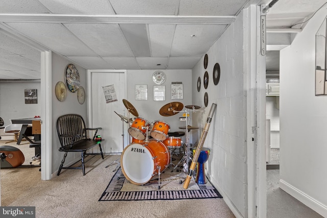 carpeted dining space featuring a paneled ceiling and baseboards