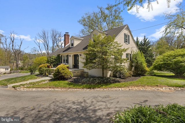 view of side of property featuring roof with shingles, stucco siding, and a chimney