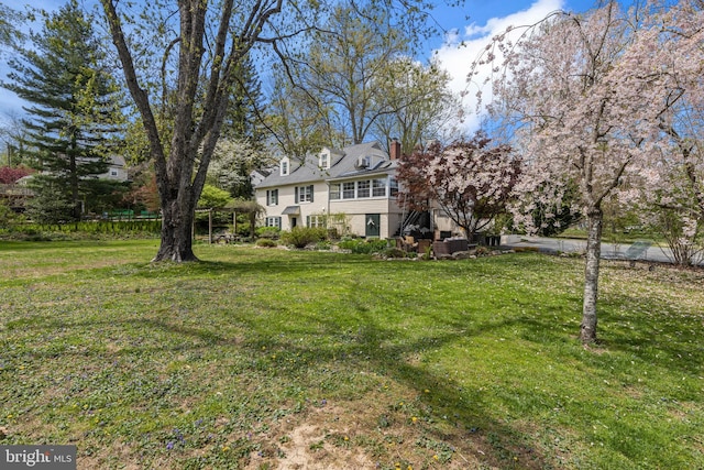exterior space with a chimney and a front lawn