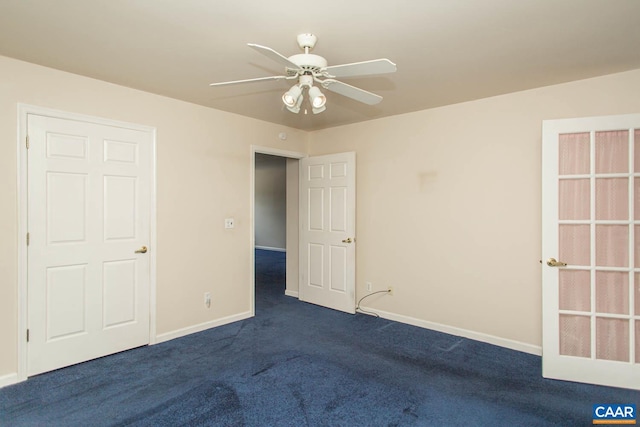 unfurnished bedroom featuring dark colored carpet, baseboards, and a ceiling fan