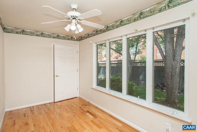 empty room featuring baseboards, a ceiling fan, and wood finished floors