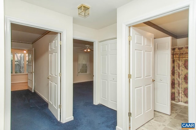 hall featuring baseboards and carpet