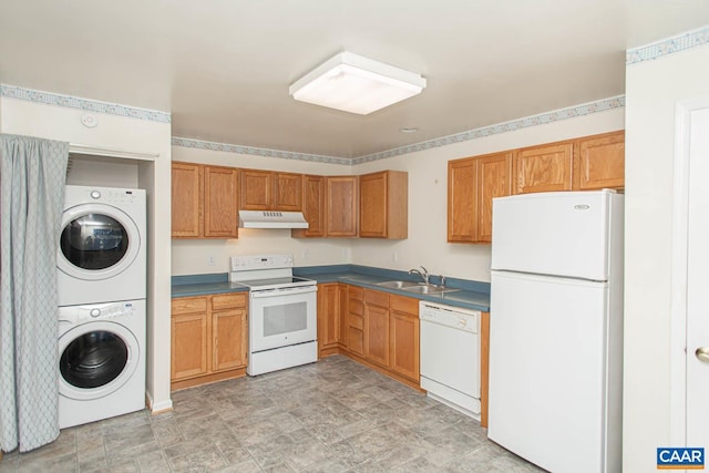 kitchen with stacked washer and dryer, a sink, stone finish floor, white appliances, and under cabinet range hood