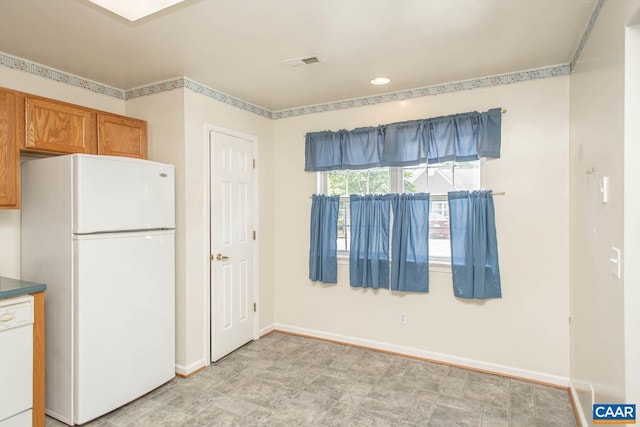 kitchen with brown cabinetry, visible vents, baseboards, white appliances, and recessed lighting