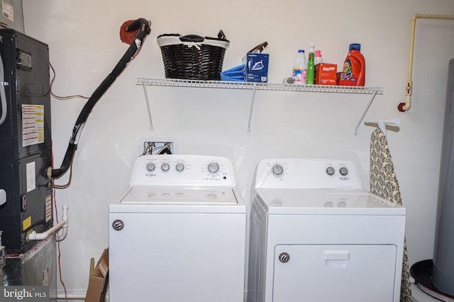 washroom featuring washing machine and clothes dryer, heating unit, and water heater