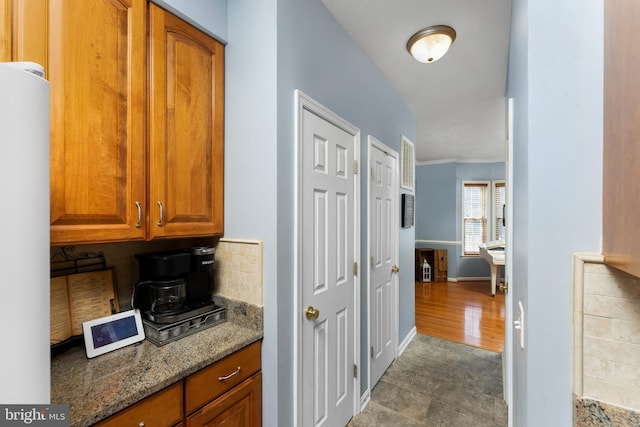 3 Oleander Dr, Stafford, VA 22554 - interior space featuring brown cabinets, freestanding refrigerator, light stone counters, decorative backsplash, and baseboards