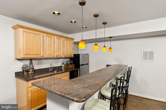 3 Oleander Dr, Stafford, VA 22554 - kitchen with freestanding refrigerator, light brown cabinets, a breakfast bar, visible vents, and a sink