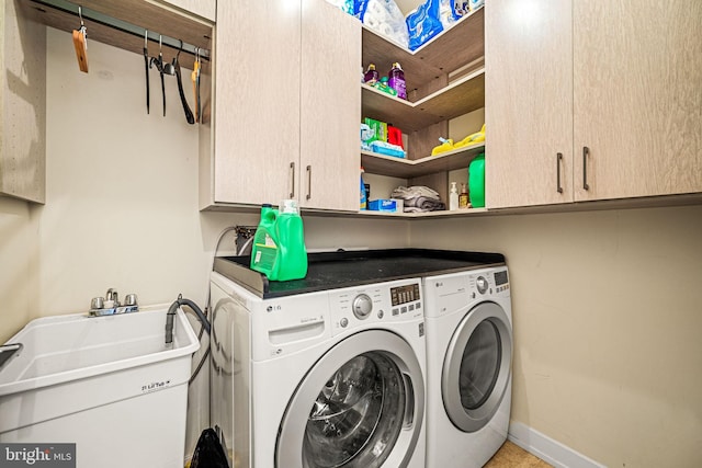 laundry room with cabinet space, independent washer and dryer, and baseboards