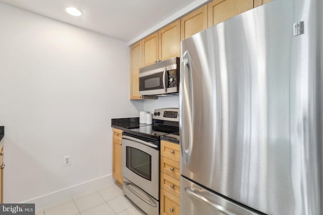 2001 15th St N Unit 207, Arlington, VA 22201 - kitchen with light brown cabinetry, light tile patterned floors, baseboards, dark countertops, and appliances with stainless steel finishes