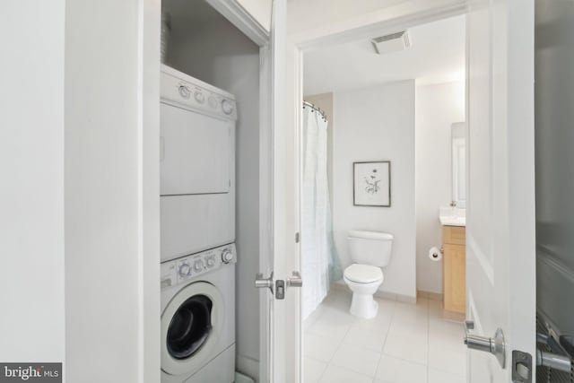 2001 15th St N Unit 207, Arlington, VA 22201 - bathroom with toilet, stacked washer and dryer, tile patterned floors, visible vents, and vanity