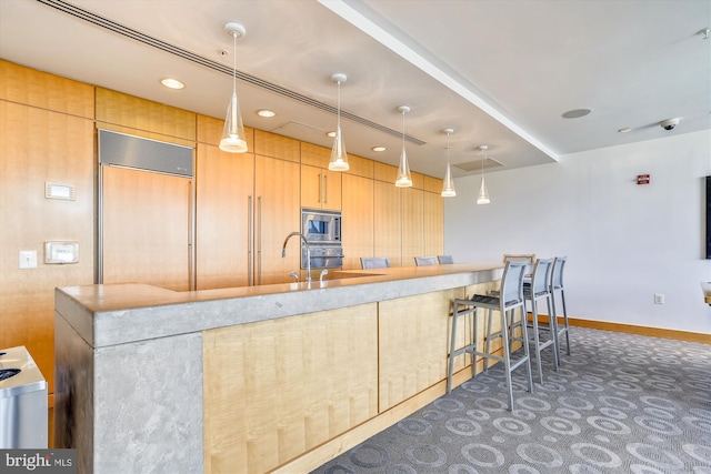 2001 15th St N Unit 207, Arlington, VA 22201 - kitchen with built in appliances, a breakfast bar, baseboards, and pendant lighting