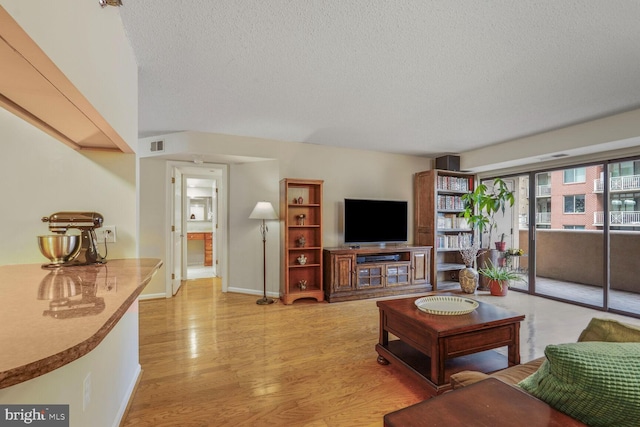 living room featuring a textured ceiling and light wood-type flooring